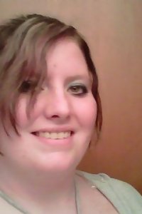 Full-figured chick in leather lingerie invitingly posing in a bedroom